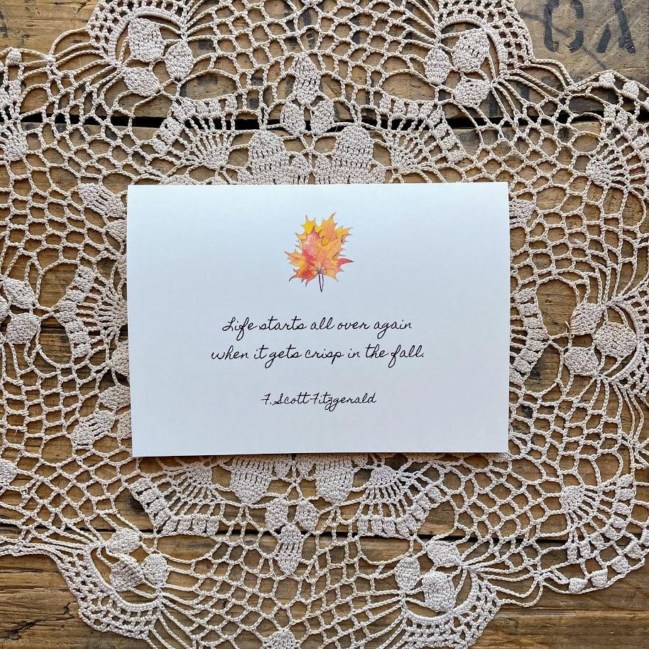 F. Scott Fitzgerald's quote "Life starts all over again when it gets crisp in the fall." on a blank notecard with original fall leaves watercolor image by artist Patricia Shaw.